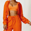 The model wearing Malibu Prison Orange Long-sleeved Sweater - NUFIT STORE front view slimming shaper tight lifting jumpsuit romper leggings bodysuit yoga outfit set